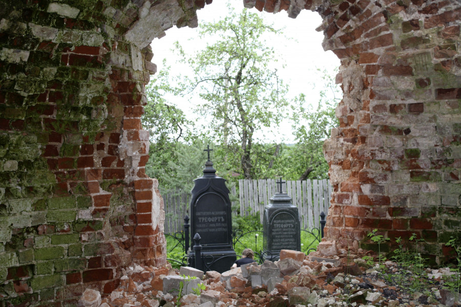 Через разрушенную абсиду церкви видно семейное захоронение Трефортов